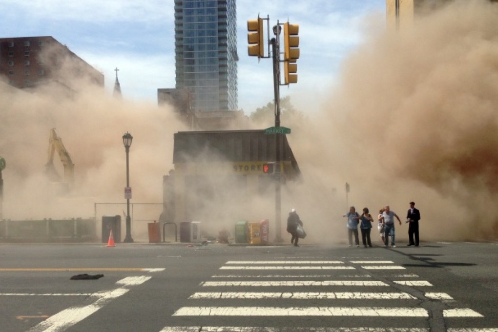 A dust cloud rises as people run from the scene of a building collapse on the edge of Philadelphia. Photo: AP