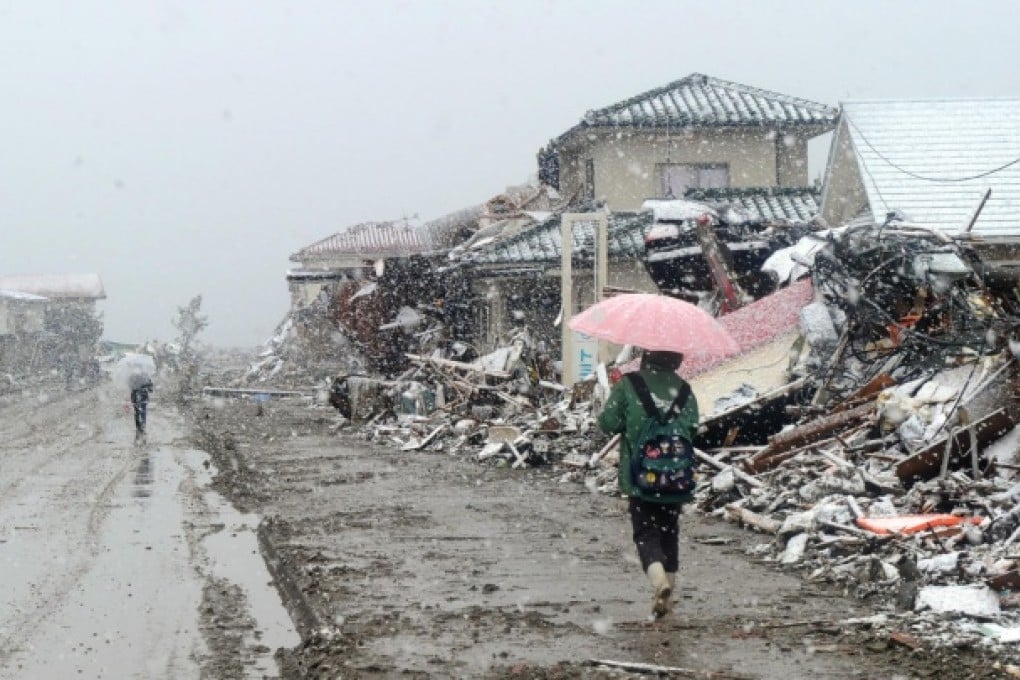 Survivors walk amid the real devastation caused by the Tohoku disaster in Natori, Miagi Prefecture, just a few days after the earthquake and tsunami. Photo: AFP