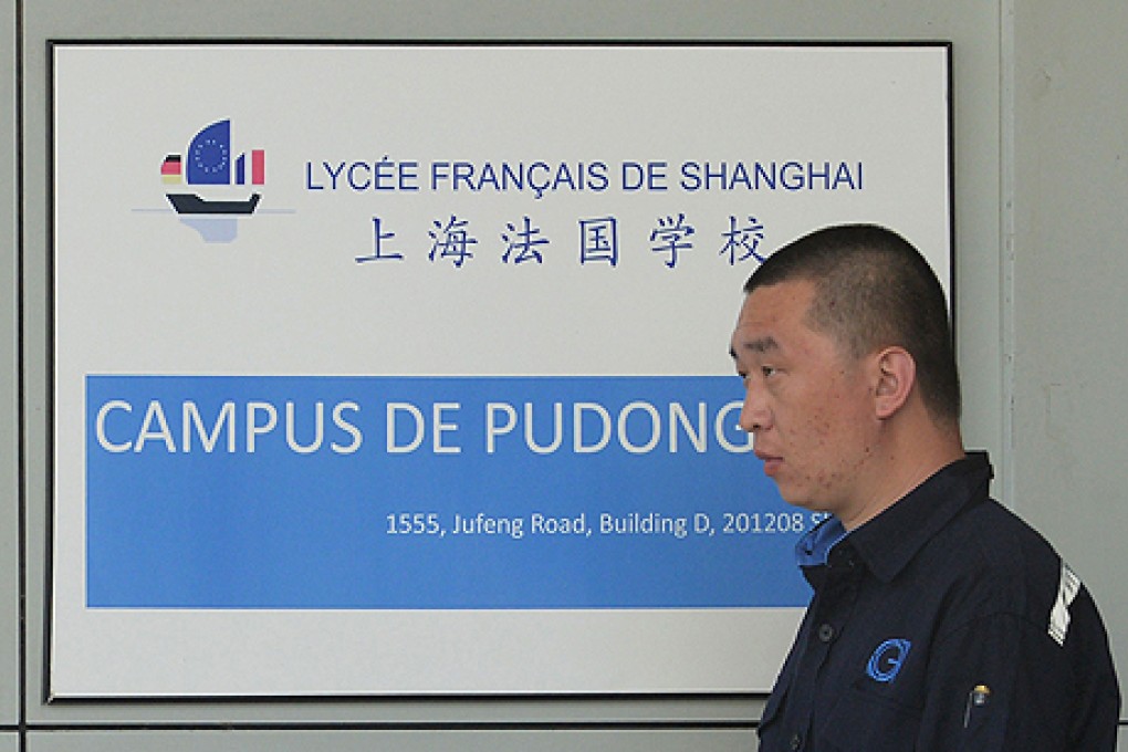 A security guard at the Lycee Francais de Shanghai where an American teacher is accused of sexually assaulting numerous students. Photo: AFP