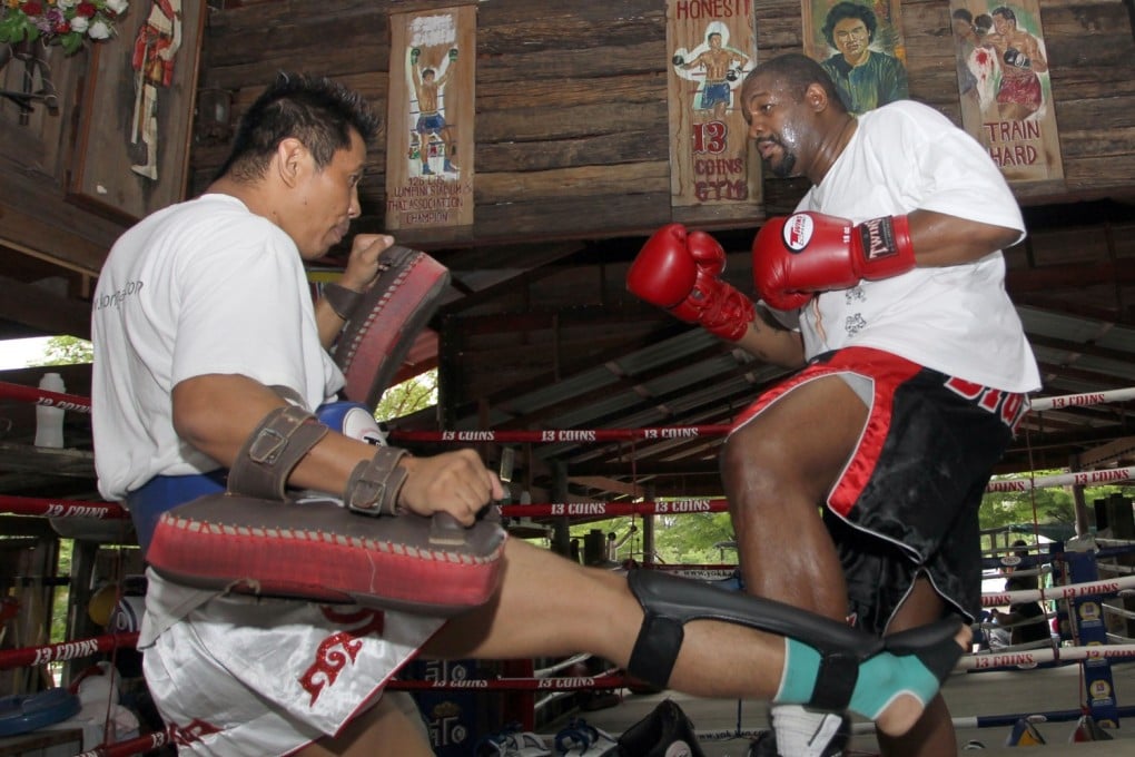 Former world heavyweight boxing champion Riddick Bowe of the US, right, trains a Muay Thai with his Thai partner at a gym in Bangkok, Thailand. Photo: AFP