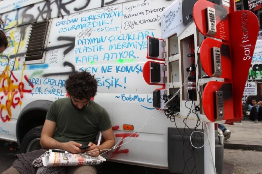 Protesters in Instanbul's Taksim Square charge their phones at a mobile station as they dig in for a weekend camping out. Photo: AP