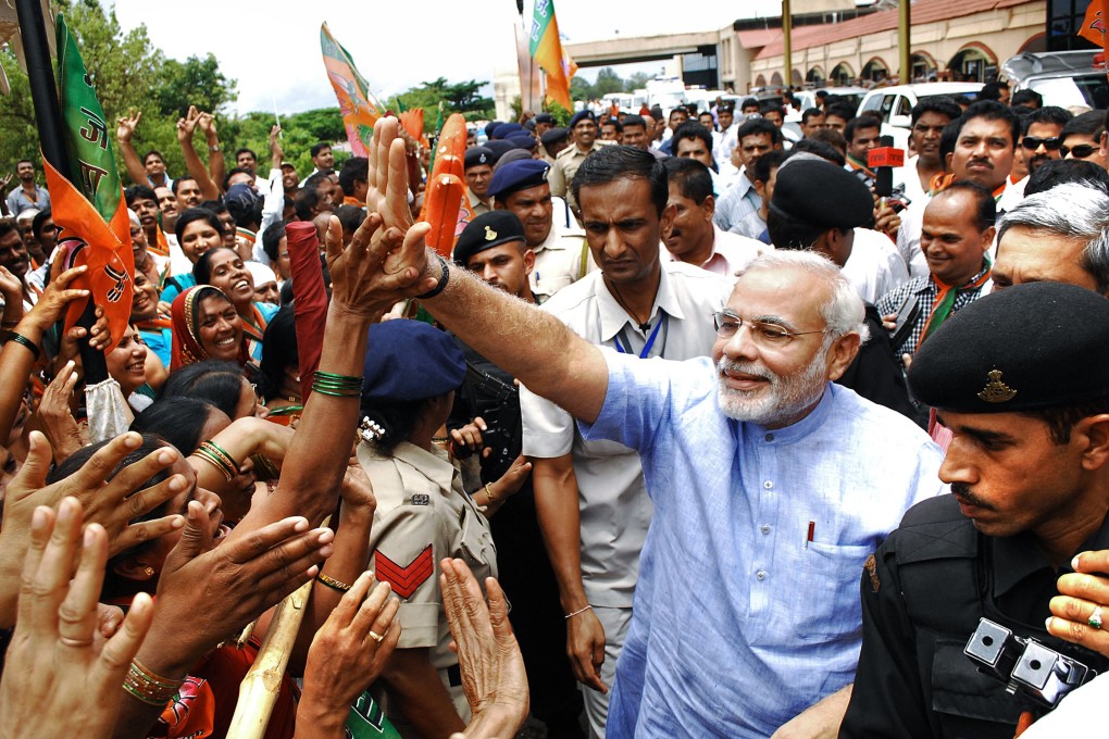 Narendra Modi (in blue) greets supporters upon arrival in Goa on Friday. Photo: AFP