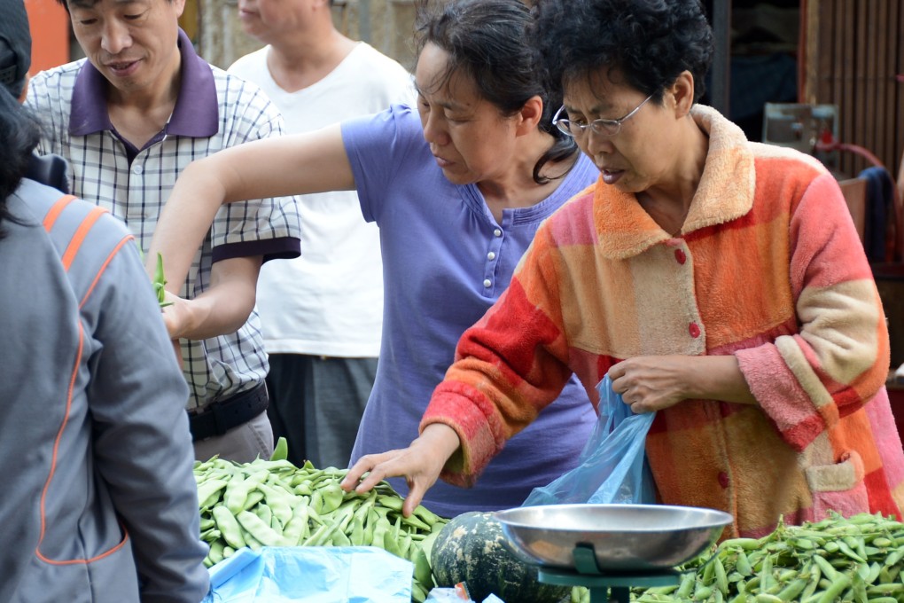 A woman chooses vegetables in a market in Changchun, China's Jilin Province. Vegetable prices fell 13.8 per cent in May from April, dragging down the month-on-month headline CPI by 0.5 percentage points. Photo: Xinhua