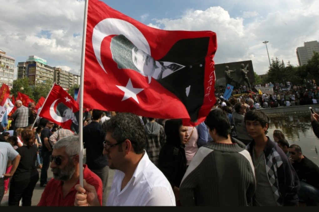 Turkish protesters, waving posters of Turkey's founder Kemal Ataturk, gather at Kizilay Square in Ankara, Turkey. Photo: AP