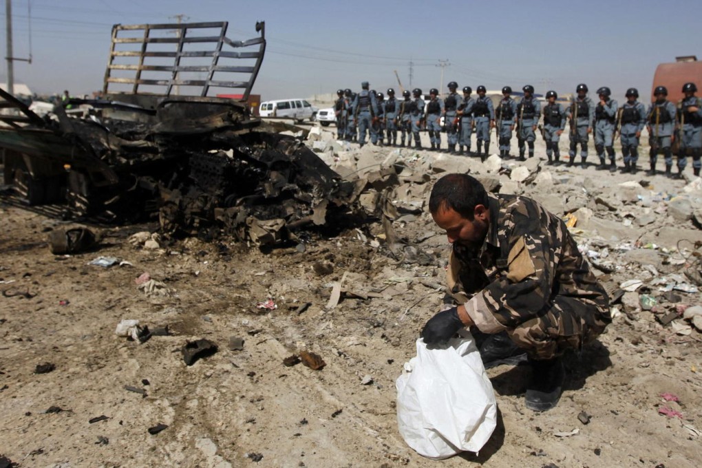 An Afghan security officer collects evidence at the site of the pre-dawn attack by Taliban insurgents, including two suicide bombers, at the airport complex in Kabul. Photo: Reuters