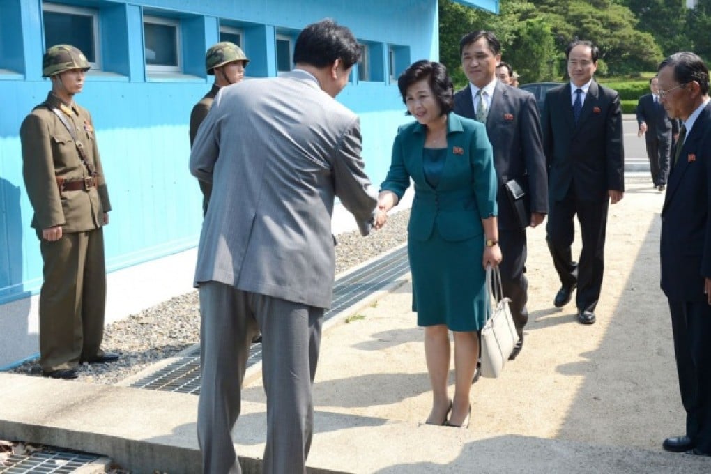 A South Korean official (front) shakes hands across the border with North Korean envoy Kim Song-hye at Panmunjom. Photo: Reuters