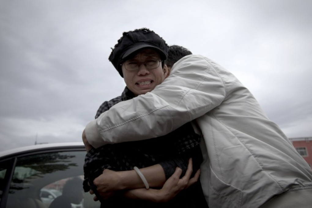 A relative comforts Liu Xia, wife of imprisoned Nobel Peace Prize winner Liu Xiaobo, while she cries outside Huairou Detention Center where her brother Liu Hui has been jailed in Huairou district, on the outskirts of Beijing, June 9, 2013.
