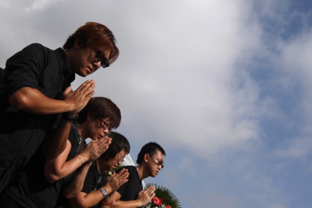 Survivors of the hostage shootings and relatives of the victims offer prayers during a Buddhist ceremony at the scene of the tragedy in Manila. Photo: Felix Wong
