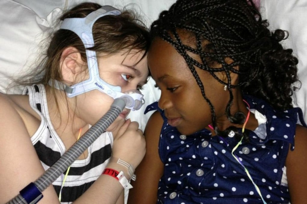 Sarah Murnaghan (left) lies in her hospital bed next to adopted sister Ellas. A genetic disease has ravaged her lungs. Photo: AP