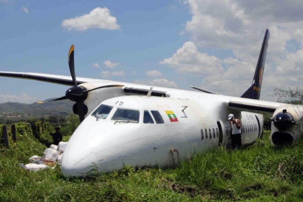 Rescuers and officials inspect the damaged Chinese-made Xian MA60 turboprop that overshot the end of the runway in Monghsat, in Shan State, May 2013. Photo: AFP