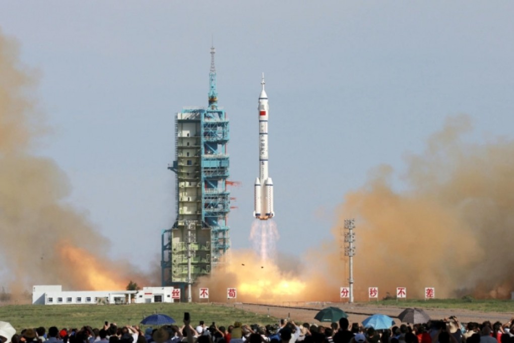 Spectators at the Jiuquan Satellite Launch Centre in Inner Mongolia watch as the Shenzhou X blasts off yesterday. The spacecraft, which has embarked on a 15-day mission, is carrying a crew of three, including the second Chinese woman to travel into space, Major Wang Yaping. Photo: AP