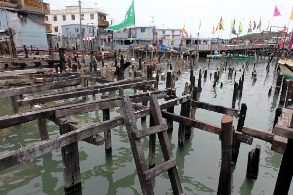 Wooden poles jutting out of the water on Kat Hing Street on Lantau are a reminder of the stilt houses that sat on top before a fire cleared everything in its path. Photo: Felix Wong
