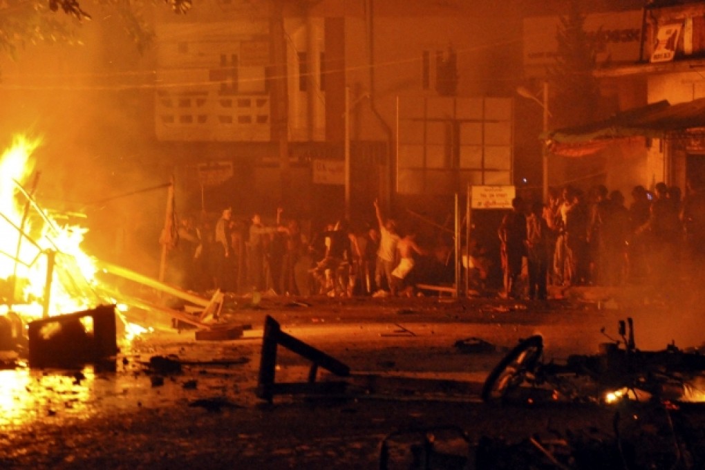 People gather around a burning mosque in Lashio, northern Shan State, Myanmar, in May 2013. Photo: AP