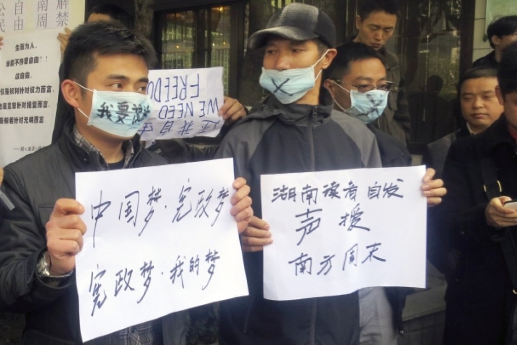 Demonstrators hold banners outside the headquarters of Southern Weekly newspaper in Guangzhou, January 8, 2013. Photo: Reuters