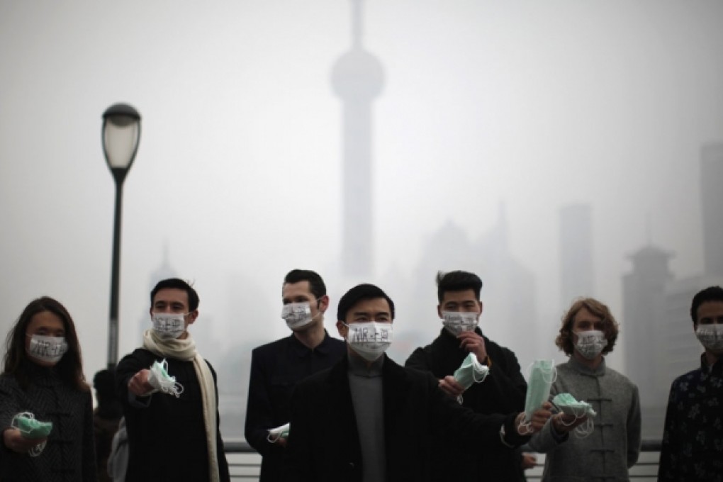 Green activists hand out masks to pedestrians on The Bund yesterday to raise awareness of air pollution in downtown Shanghai. Photo: Reuters