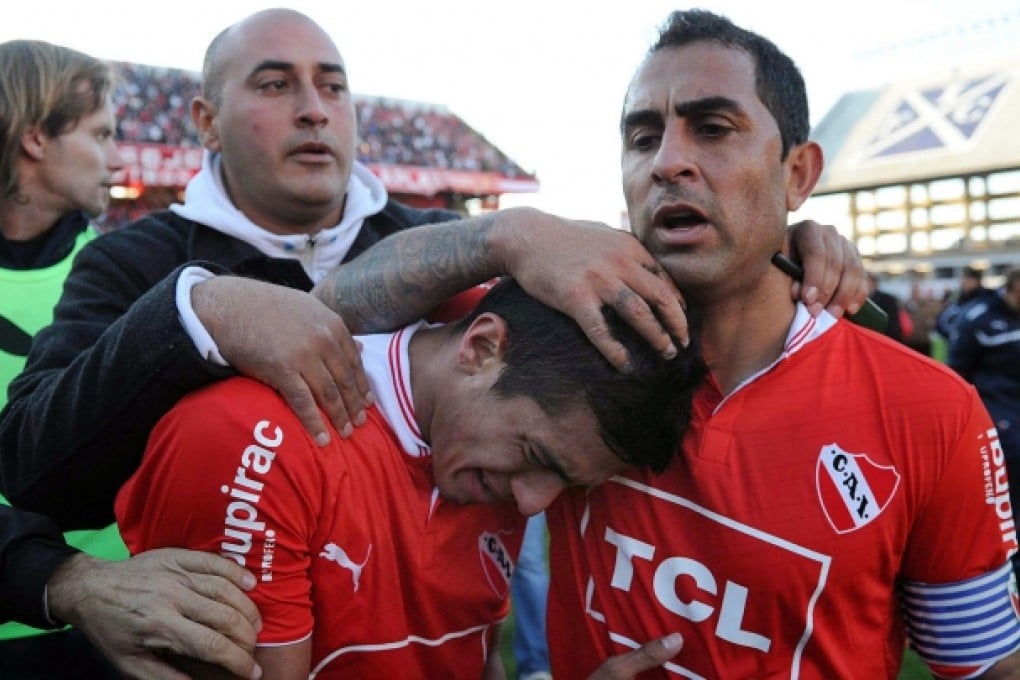 Independiente's Daniel Montenegro (right) comforts a teammate after the loss that saw the team relegated. Photo: Xinhua