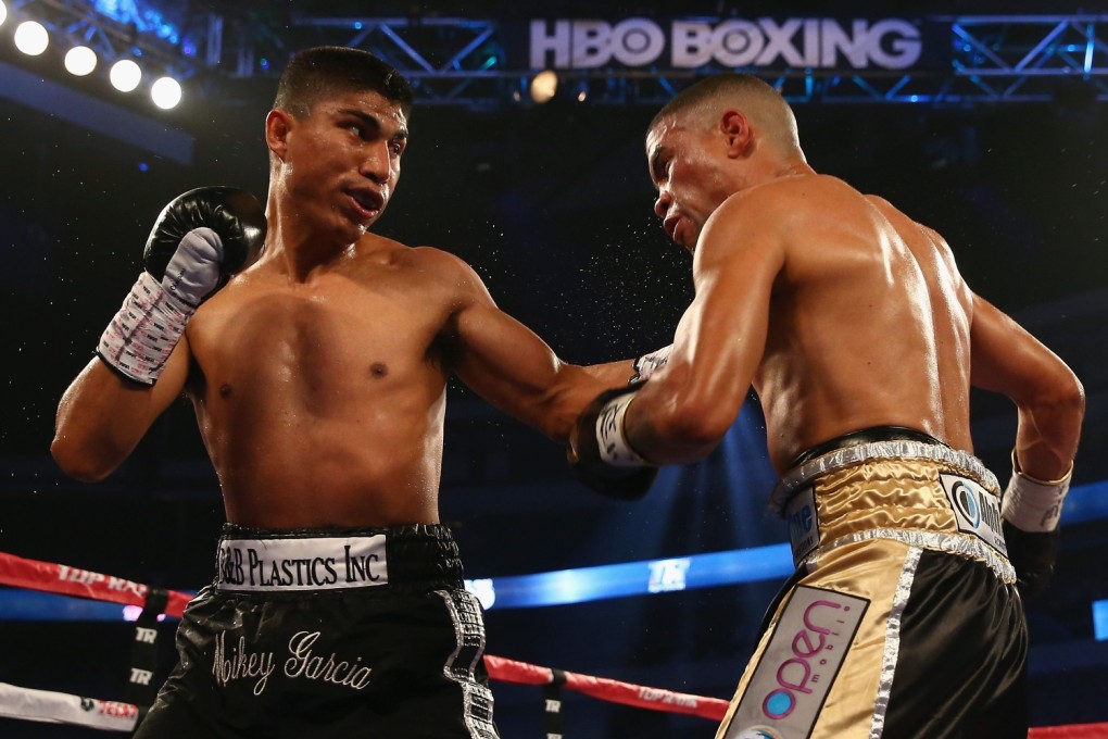 Mikey Garcia connects with a left to the face of Juan Manuel Lopez during their Vacant WBO Featherweight Title bout at American Airlines Center in Dallas, Texas. Garcia knocked out Lopez in the fourth round. Photo: AFP