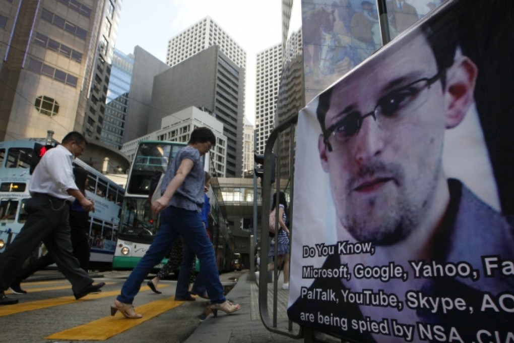 People walk past a banner supporting Edward Snowden at Central, Hong Kong's business district. Photo: AP