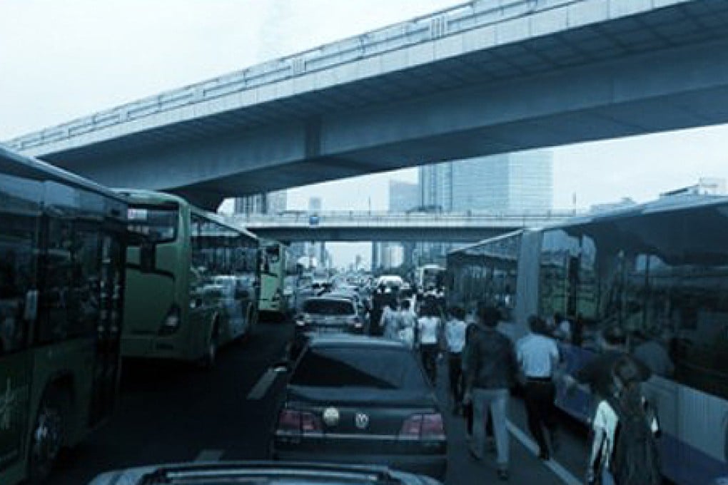 Pictured: 'zombie' commuters ditch cars and walk amid massive Beijing traffic jam