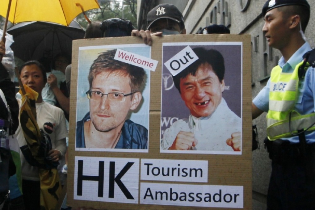 A supporter holds picture of Edward Snowden and Hong Kong movie star Jackie Chan during a protest outside the US consulate in Hong Kong on June 15, 2013. Photo: AP
