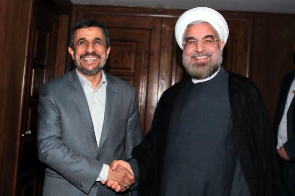 Iranian president Mahmoud Ahmadinejad meets president elect Hassan Rowhani. Photo: EPA