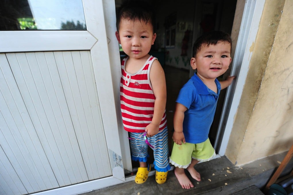 Two boys stand in the doorway of their playroom at an orphanage ont he outskirts of Beijing. The rules for adopting and handling abandoned infants in China have become tougher. Photo: AFP