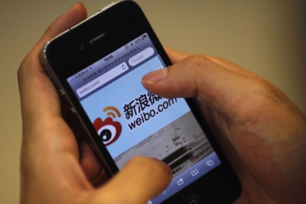 An iPhone user visits Sina Weibo. The microblogging platform has received thousands of comments on a Communist Party magazine which accuses Chinese net users of spreading false information. Photo: Reuters