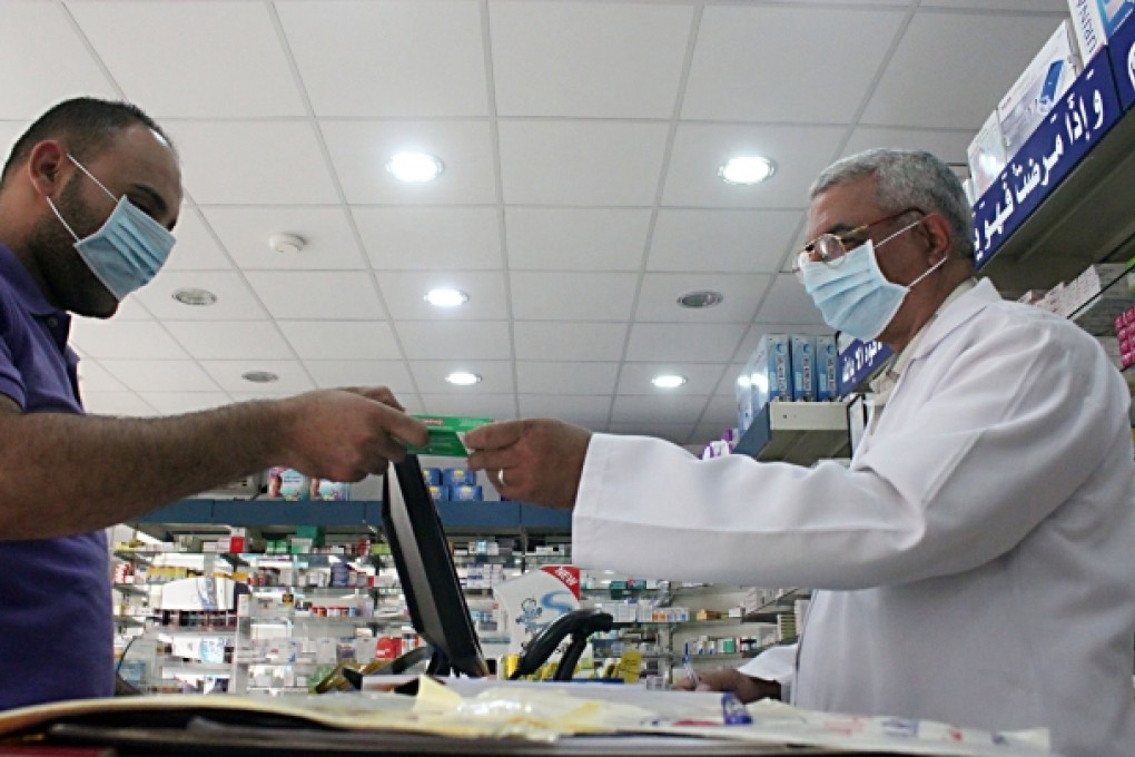 A man, wearing a surgical mask as a precautionary measure against the novel coronavirus, pays for medicine at a hospital pharmacy in Khobar city. Photo: Reuters