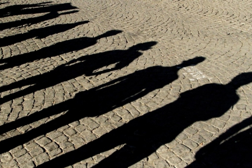 Turkish protesters cast shadows as they stand in Taksim Square during a "standing man" protest. Photo: EPA