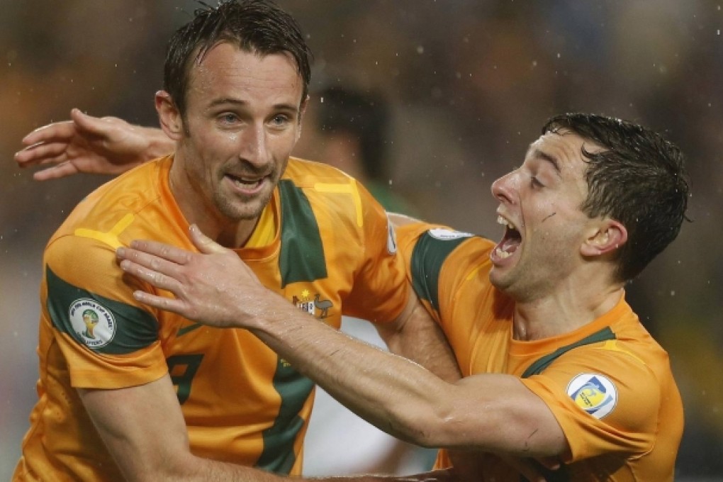 Australia's Josh Kennedy is embraced by teammate Tommy Oar after scoring in the 83rd minute against Iraq in Sydney. Photo: Reuters