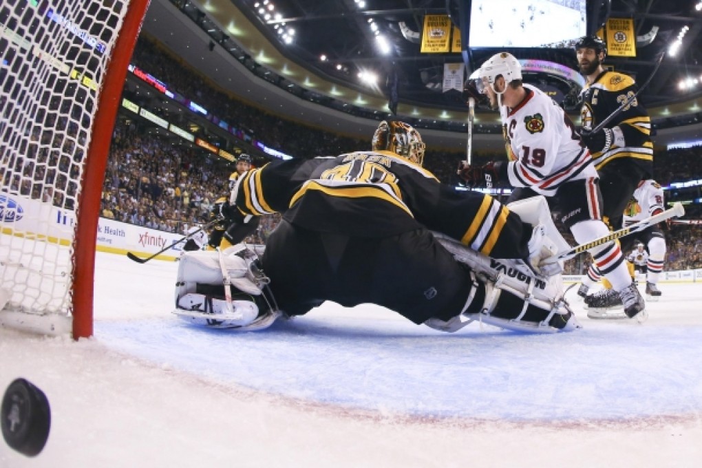 The winning goal by Brent Seabrook, not shown, crosses into the net behind Boston Bruins goalie Tuukka Rask. Photo: AP