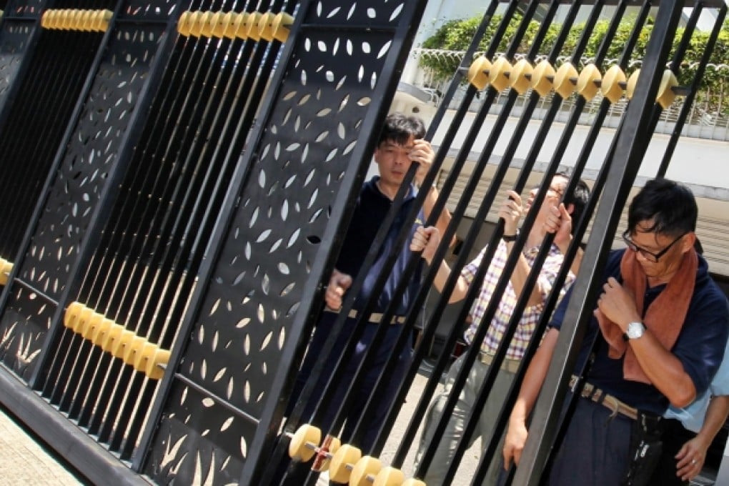 Workers fix the front gate at the house in Mong Kok. Photo: SCMP