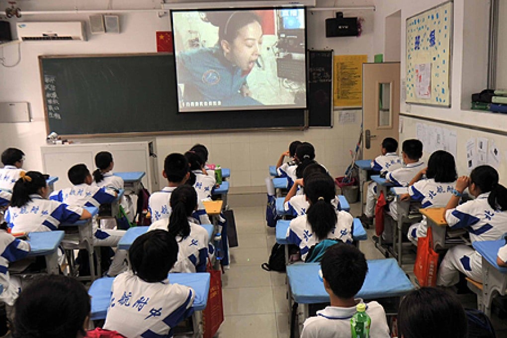 Students watch the live video broadcast of a space lecture in Beijing. Photo: Xinhua