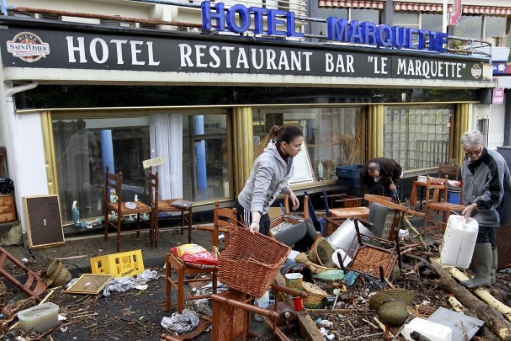 The clean-up begins at a restaurant after floods in Lourdes. Hundreds of pilgrims were evacuated as the Pau river broke its banks. Photo: AP