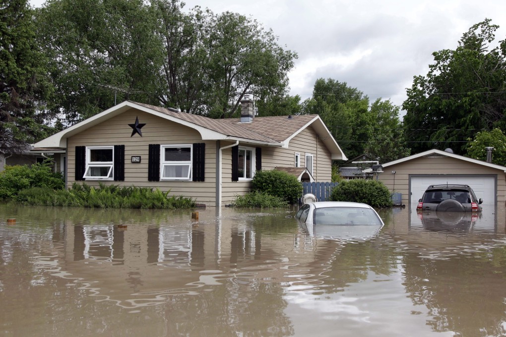 Cars and homes are submerged in flood waters in High River, Alberta. Calgary city officials say as many as 100,000 people could be forced from their homes due to heavy flooding. Photo: AP