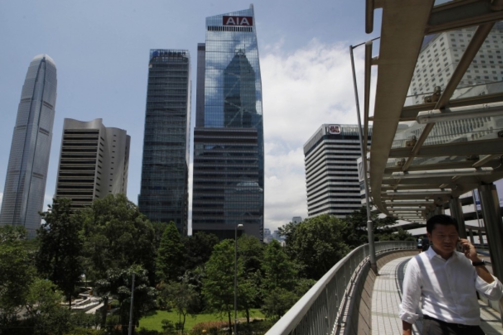 Pedestrians walk on an overpass during sunset in the business district of Central in Hong Kong. Photo: AP