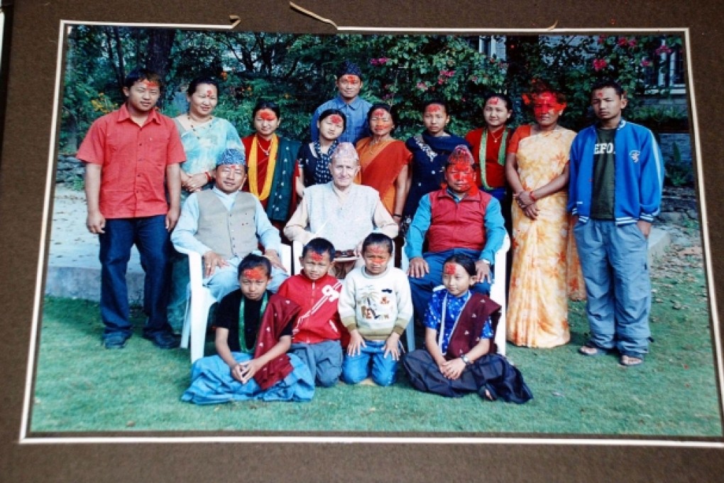John Cross sits with adopted son Buddhiman (to his left) and his extended family during a festival. Photo: Mahesh Shrestha