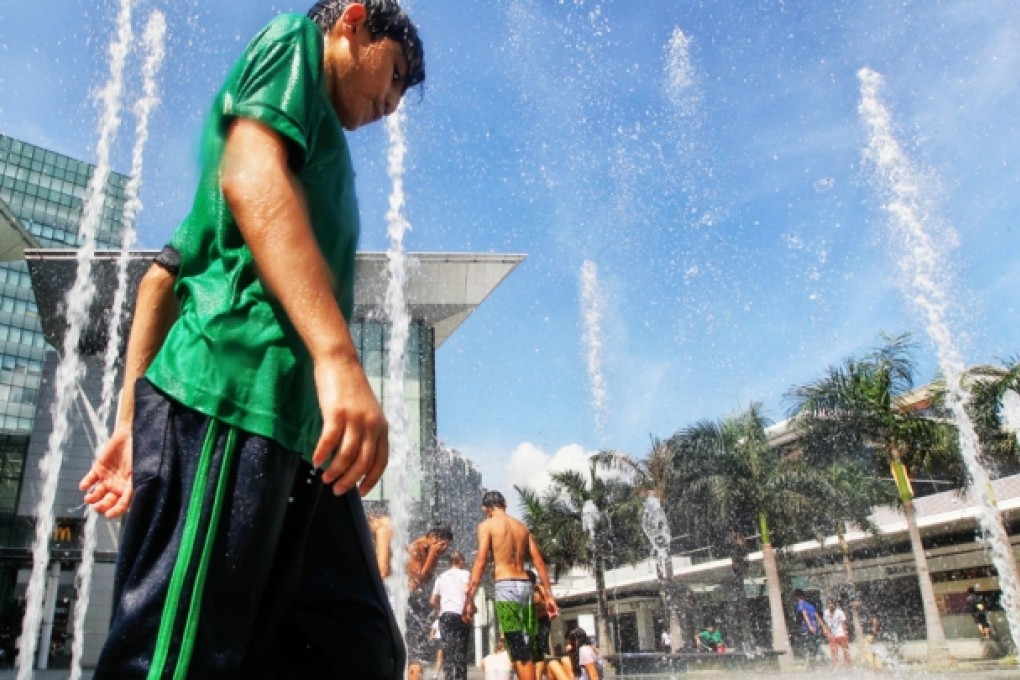 Children try to get a little relief from the heat by dousing themselves at a fountain in Tung Chung as the temperature reaches 34.2 degrees Celsius. Photo: Felix Wong