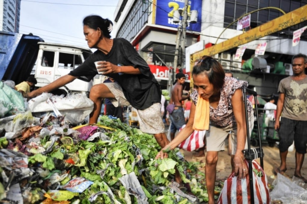 Scavenging for food, such as at this market in Manila, is part of daily life for those at the bottom of the pile. Photo: NYT