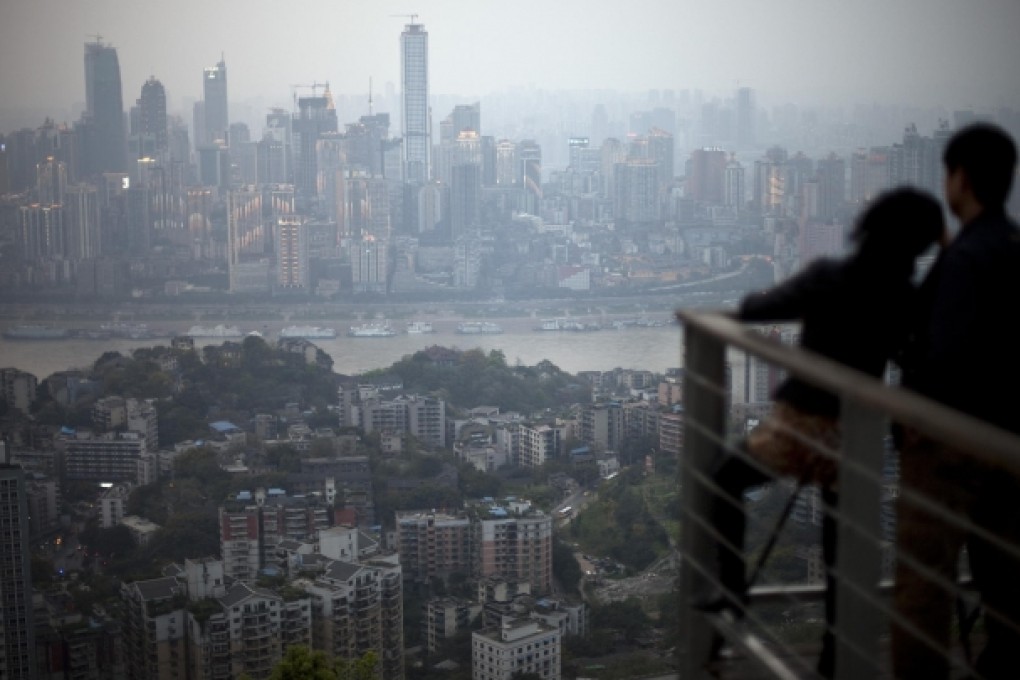 A couple enjoy the Chongqing skyline from their balcony. More banks are expected to tap wealthy investors in such two-tier cities. Photo: AP