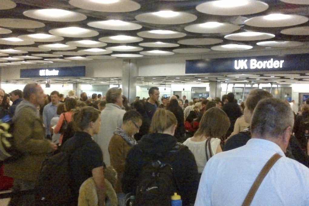 Travellers queue to be processed by UK Border Agency immigration control officers at Heathrow Airport. Photo: Reuters