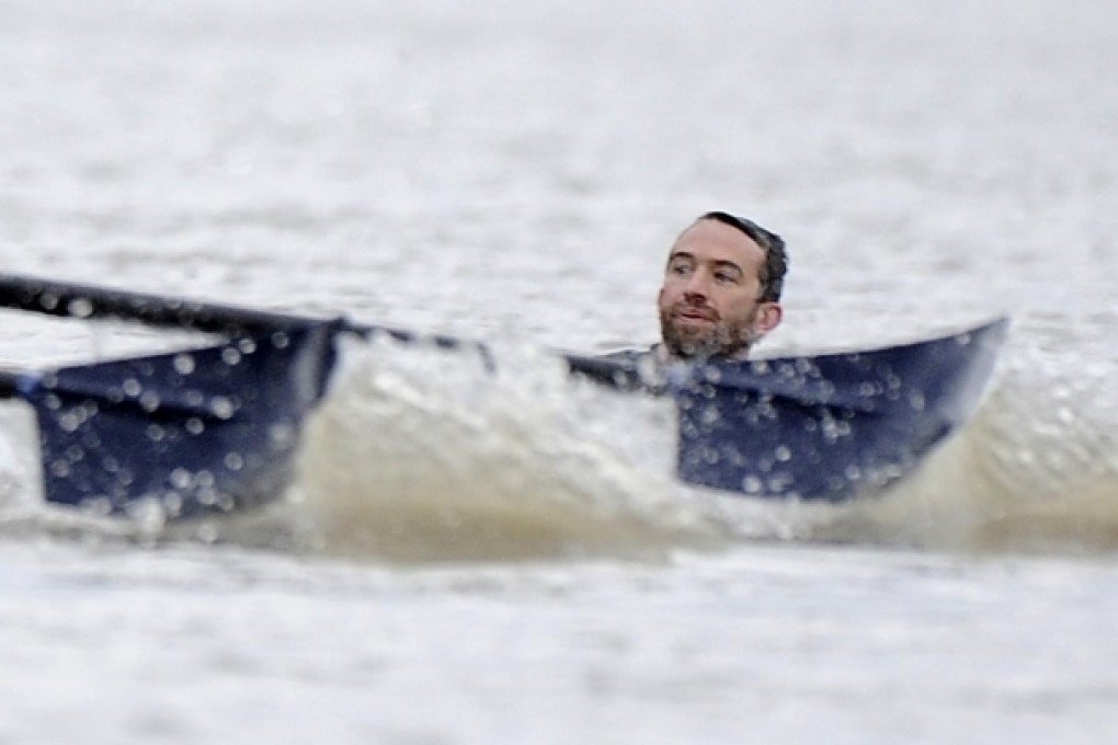 The crews approach Trenton Oldfield in the River Thames during his protest that halted the Boat Race in April last year. Photo: Reuters