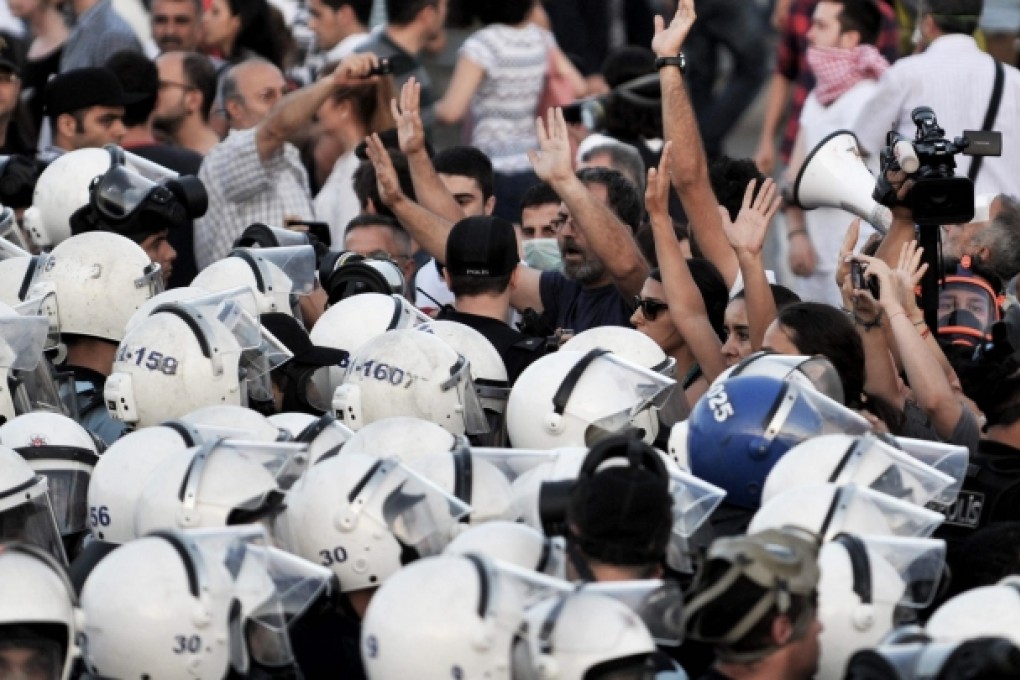 Protesters calling for the resignation of Prime Minister Recep Tayyip Erdogan try to stop riot police shortly before clashes erupted on Taksim Square in Istanbul. Photo: AFP