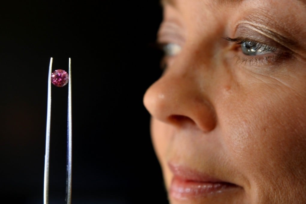 Argyle Pink Diamonds manager Josephine Johnson inspects the biggest 'red' diamond ever produced by mining giant Rio Tinto's Australian mine. Photo: AFP