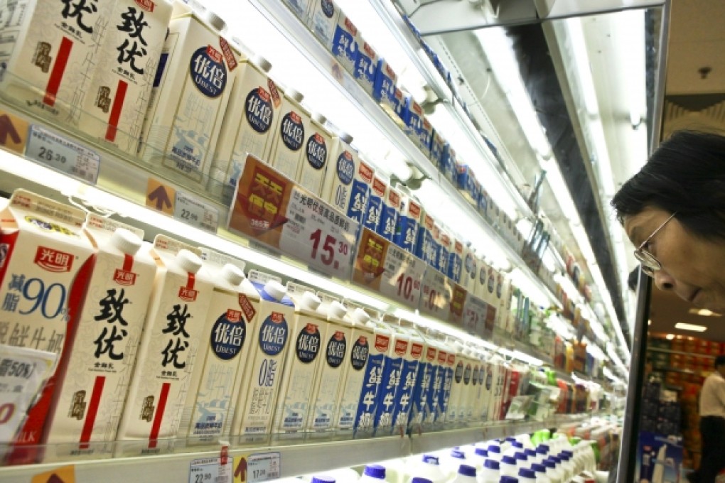 Customers look over products sold by China Bright Dairy, which will see its 51 per cent stake in Synlait diluted to 40 per cent stake after a New Zealand listing. Photo: AP