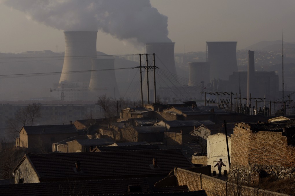 Cooling towers can be seen in the distance at a coal power plant in Xiahuayuan county, northern China's Hebei province. Photo: AP