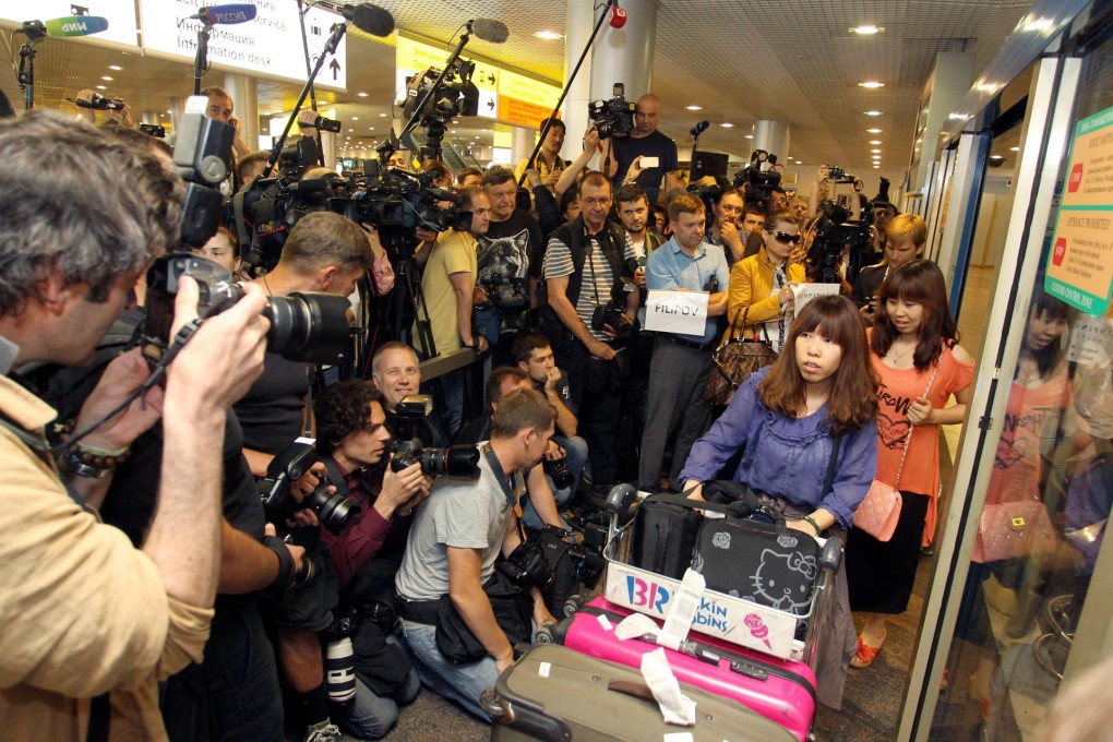 Passengers arriving in Moscow emerge from the arrivals hall to be greeted by a mob of journalists and photographers waiting fruitlessly for Edward Snowden. Photo: EPA