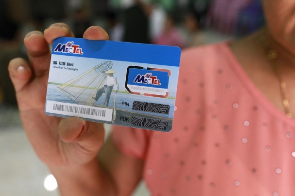A woman shows off a SIM card, which she won in a lottery, in Yangon. Photo: Reuters