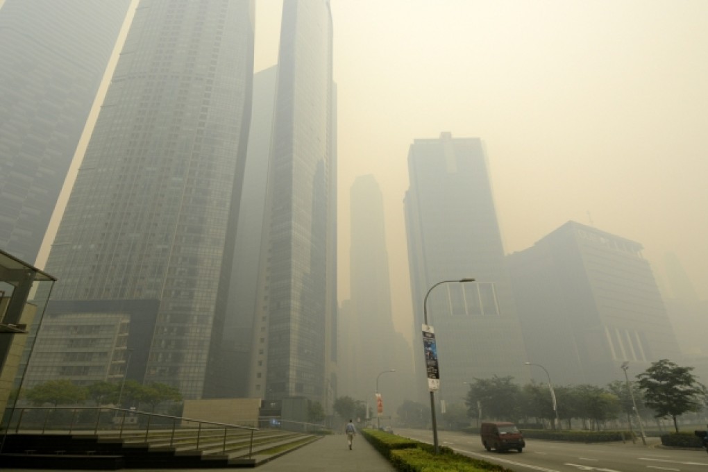 Office buildings stand shrouded in smog in Singapore. Photo: Bloomberg
