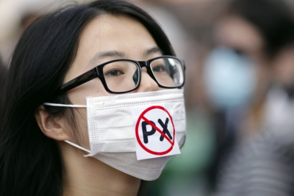 A protester wears a mask with a reference to the dangerous chemical paraxylene that the Ningbo plant already produces. Photo: Reuters